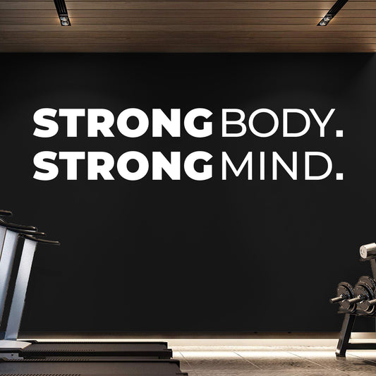 Gym interior with 'Strong Body. Strong Mind.' motivational quote on a black wall.