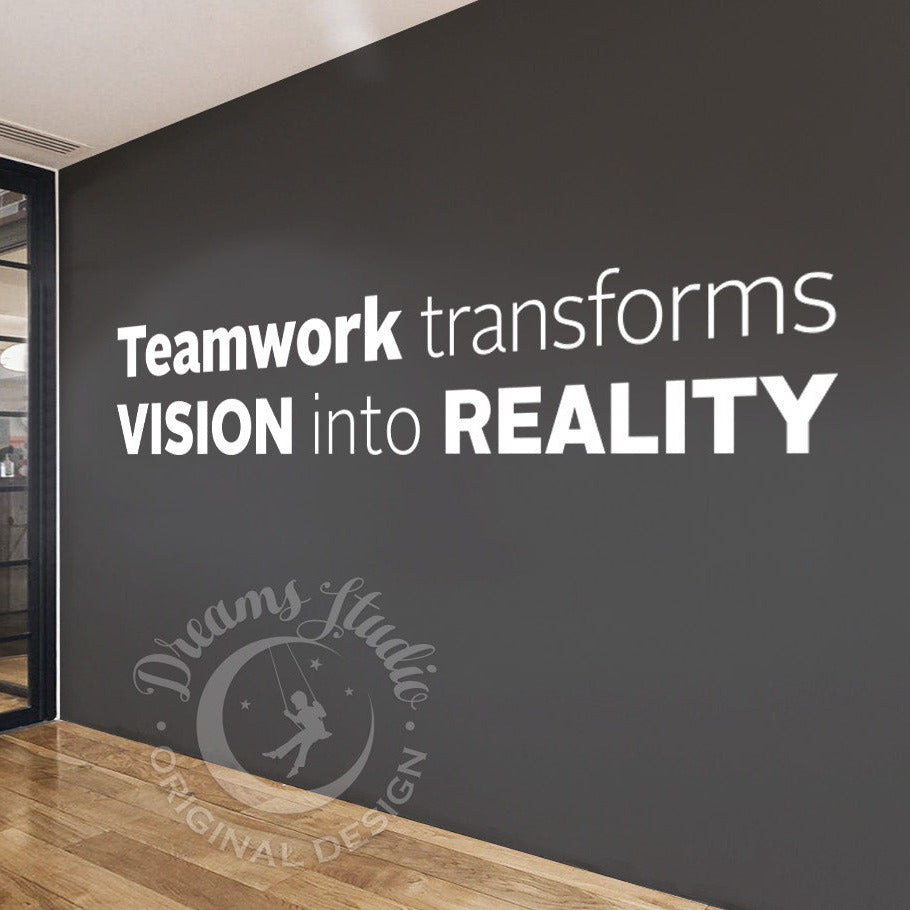 Modern office interior with motivational quote on a wall, 'Teamwork transforms VISION into REALITY'.
