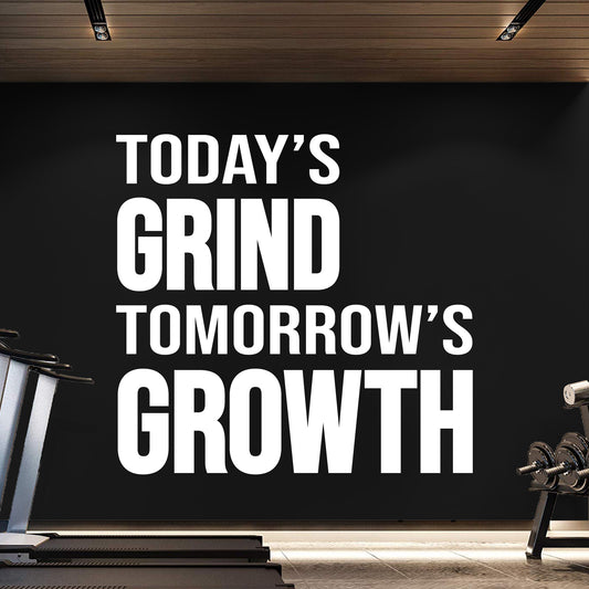 Motivational quote 'Today's Grind Tomorrow's Growth' in a gym setting.
