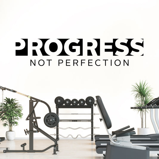 Gym equipment with 'Progress Not Perfection' text on a white background
