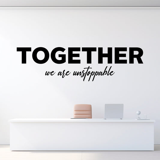 Wall decal with 'Together we are unstoppable' text on a white wall above a reception desk.