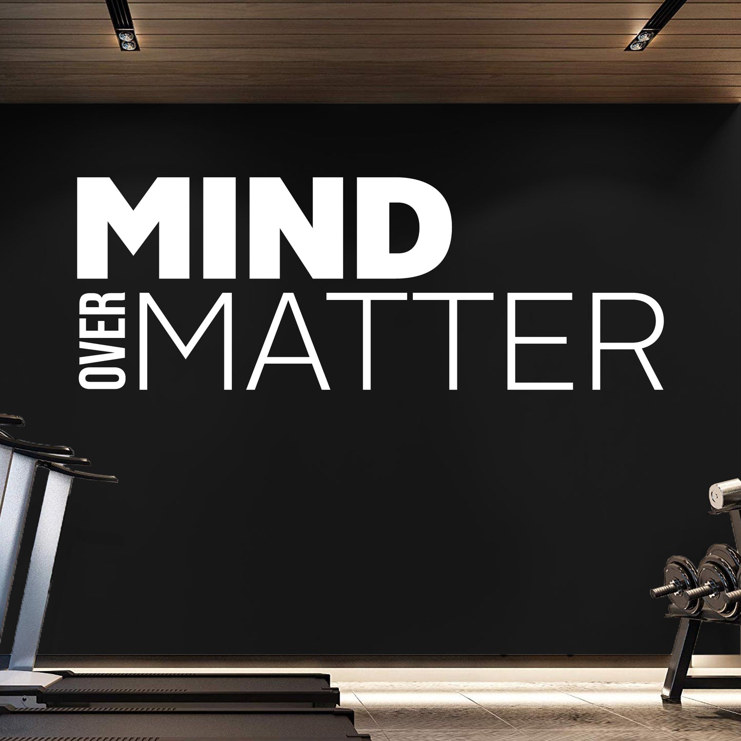 Gym interior with 'Mind Over Matter' motivational quote on a black wall.