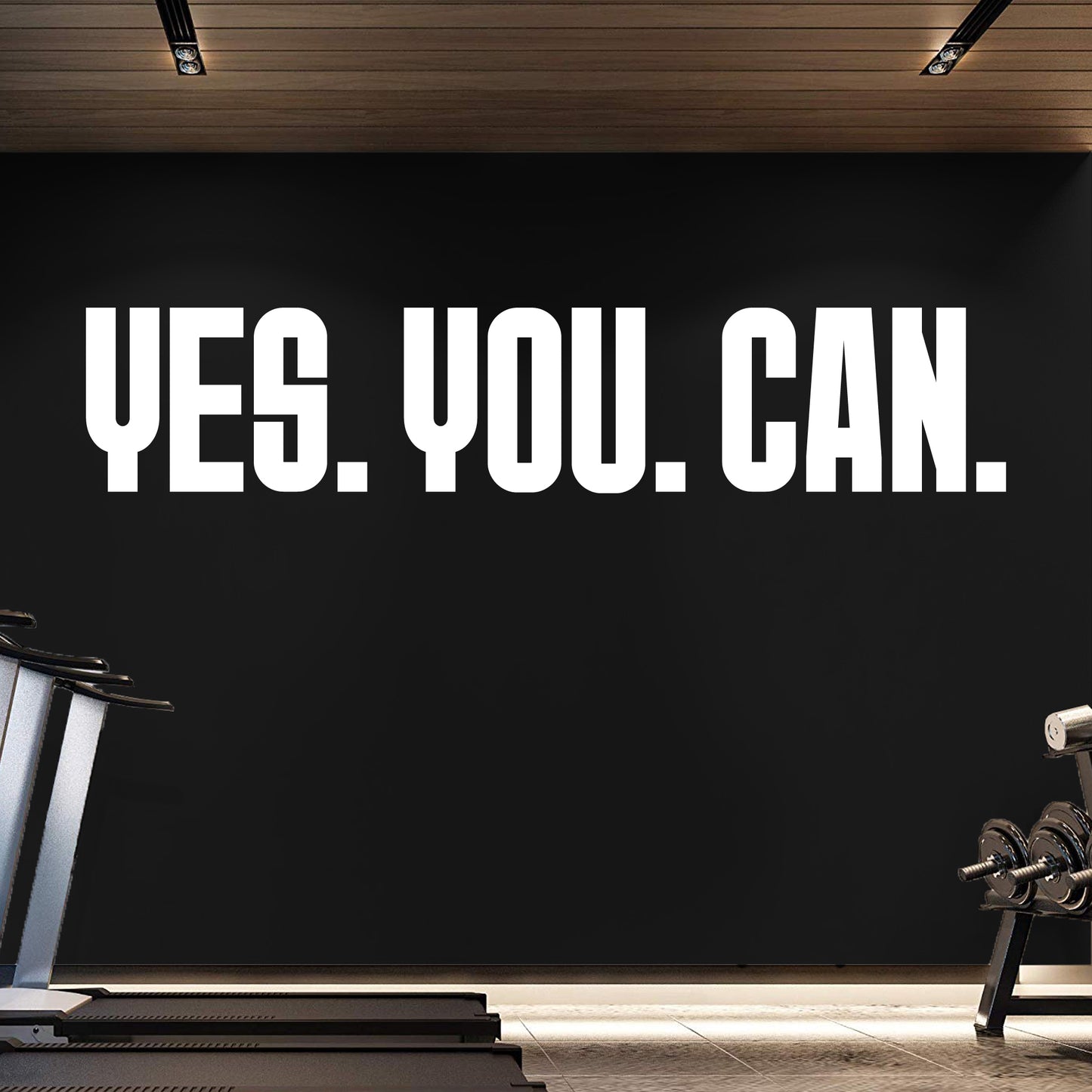 Motivational quote 'YES. YOU. CAN.' on a black wall in a gym setting.