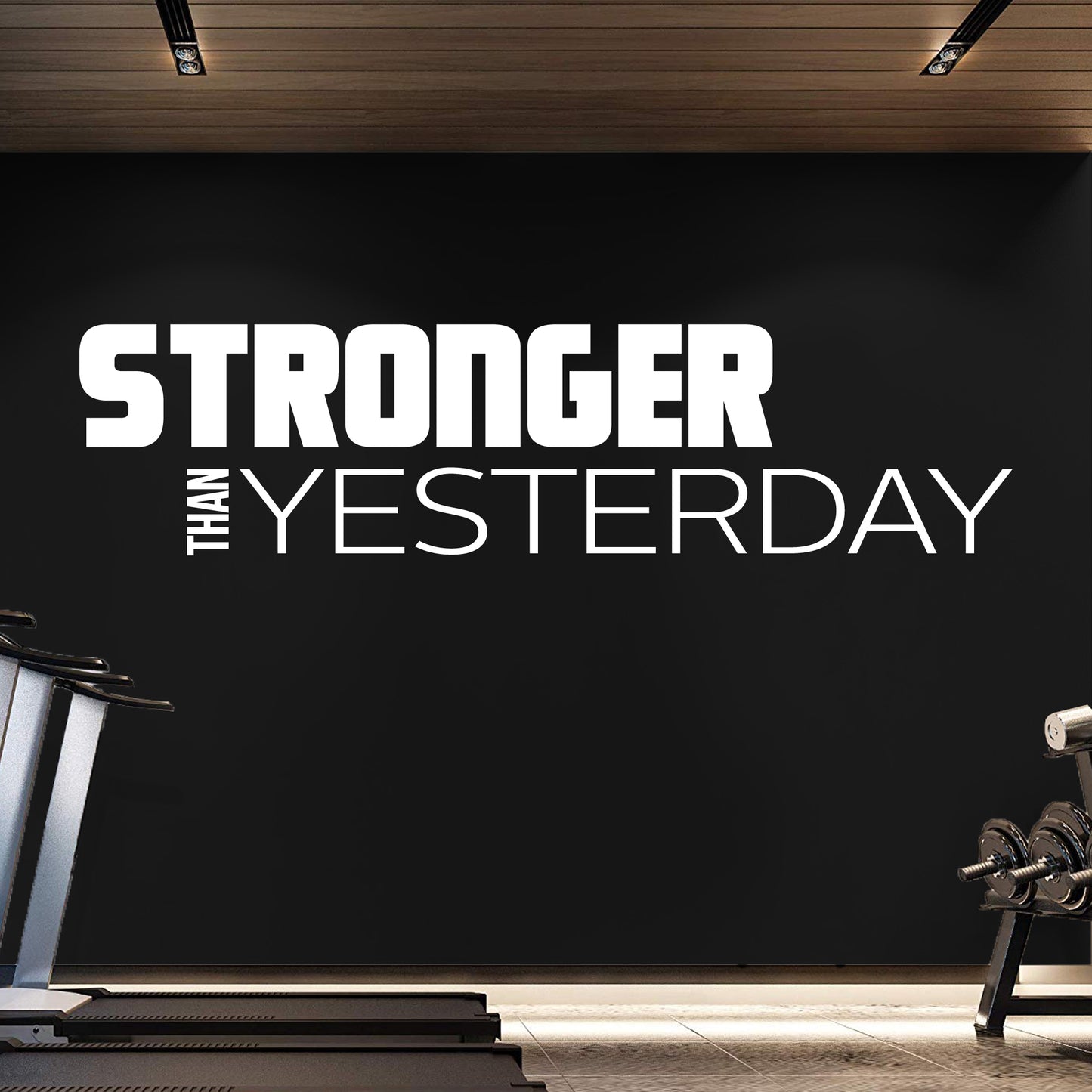 Gym interior with motivational quote 'Stronger Than Yesterday' on a black wall.