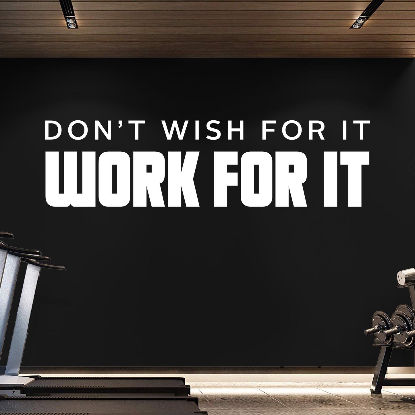 Motivational quote on a black wall in a gym setting with exercise equipment.