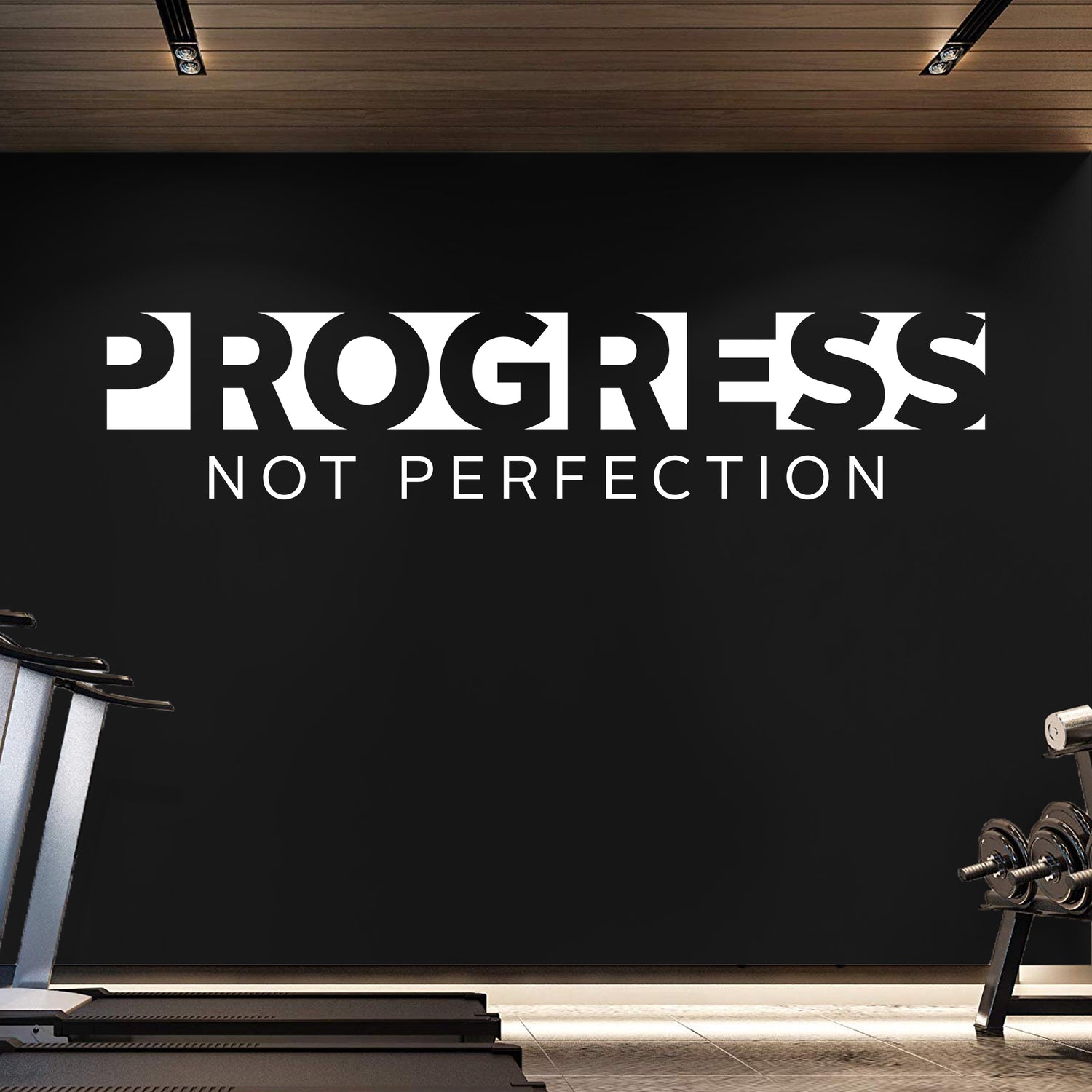 Gym interior with 'Progress Not Perfection' motivational quote on a black wall.