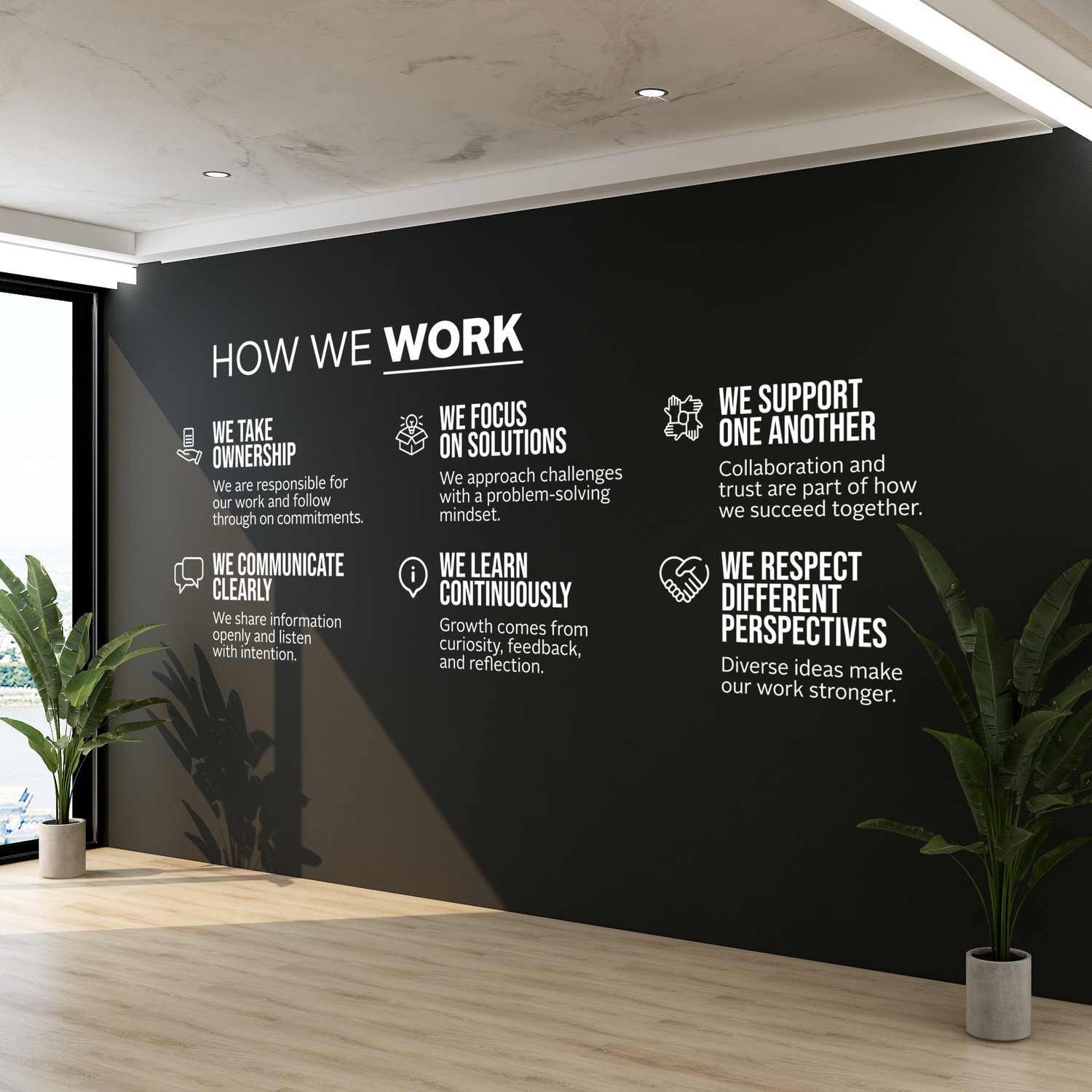 Modern office interior with a black wall displaying white text and plants.
