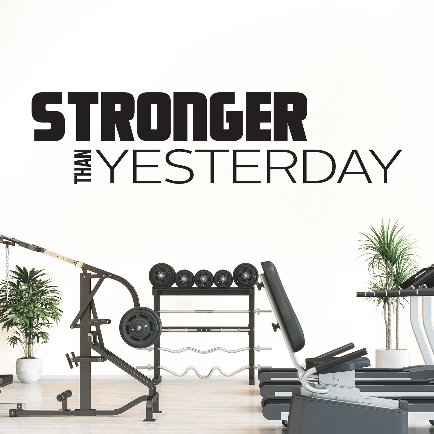 Gym equipment with 'Stronger Than Yesterday' motivational quote on a white wall.