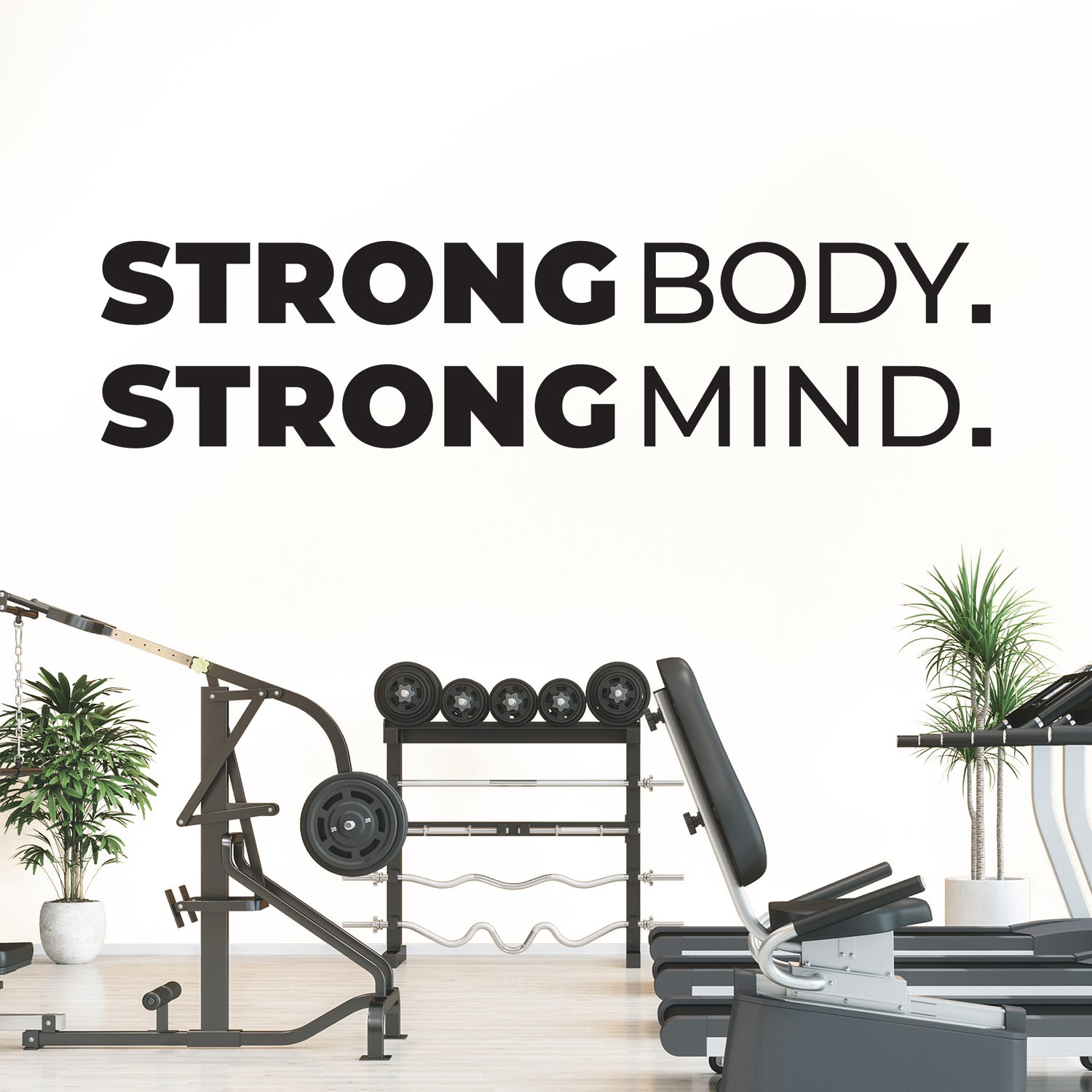 Gym equipment with 'Strong Body. Strong Mind.' text on a white wall.