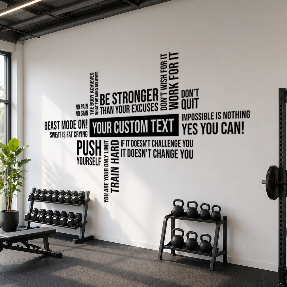 Full view of a black personalized gym word cloud wall decal with motivational fitness quotes and a customizable center text area on a white wall above dumbbells and kettlebells.