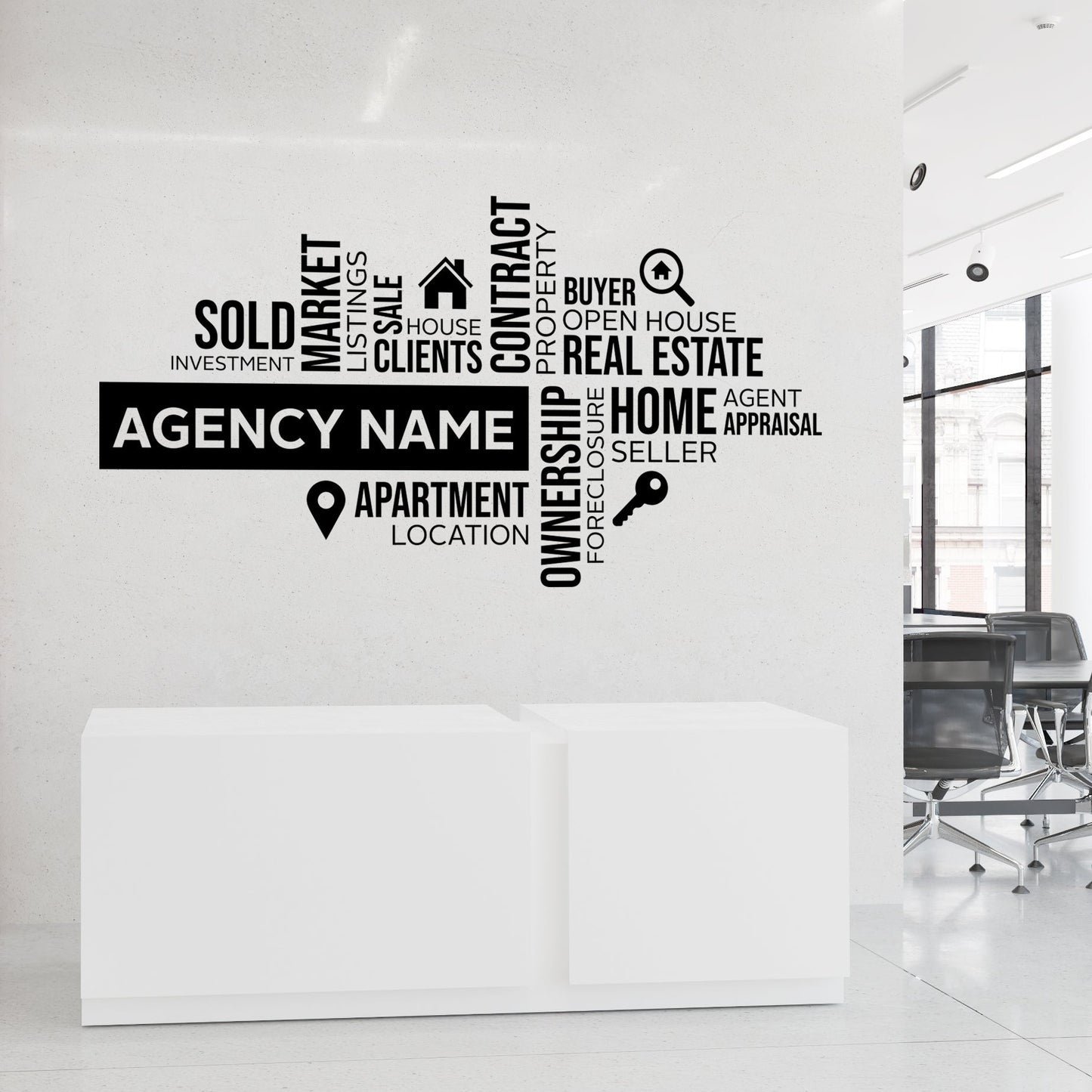 Real estate agency wall decal with various terms on a white wall.