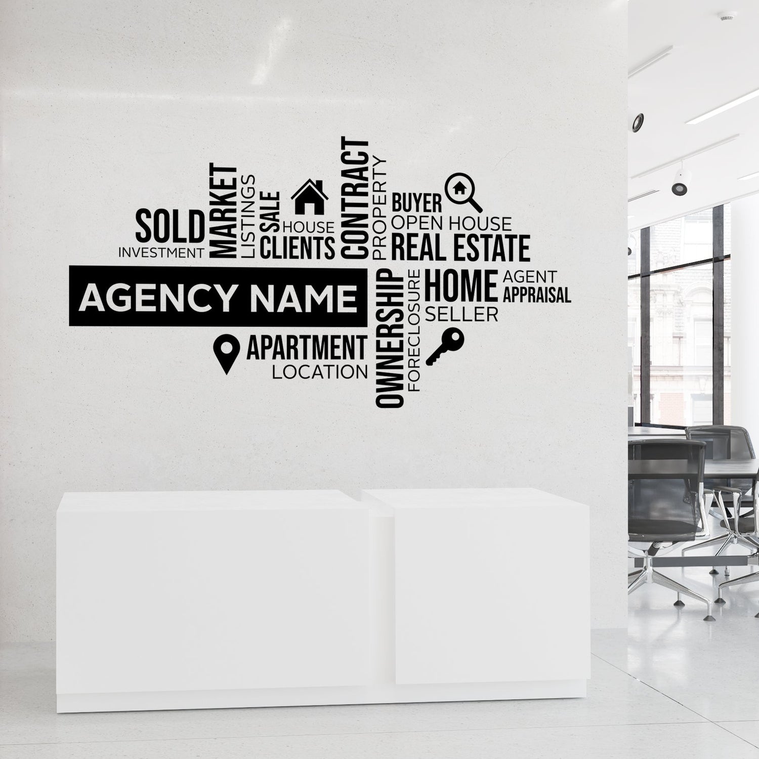 Real estate agency wall decal with various terms on a white wall.