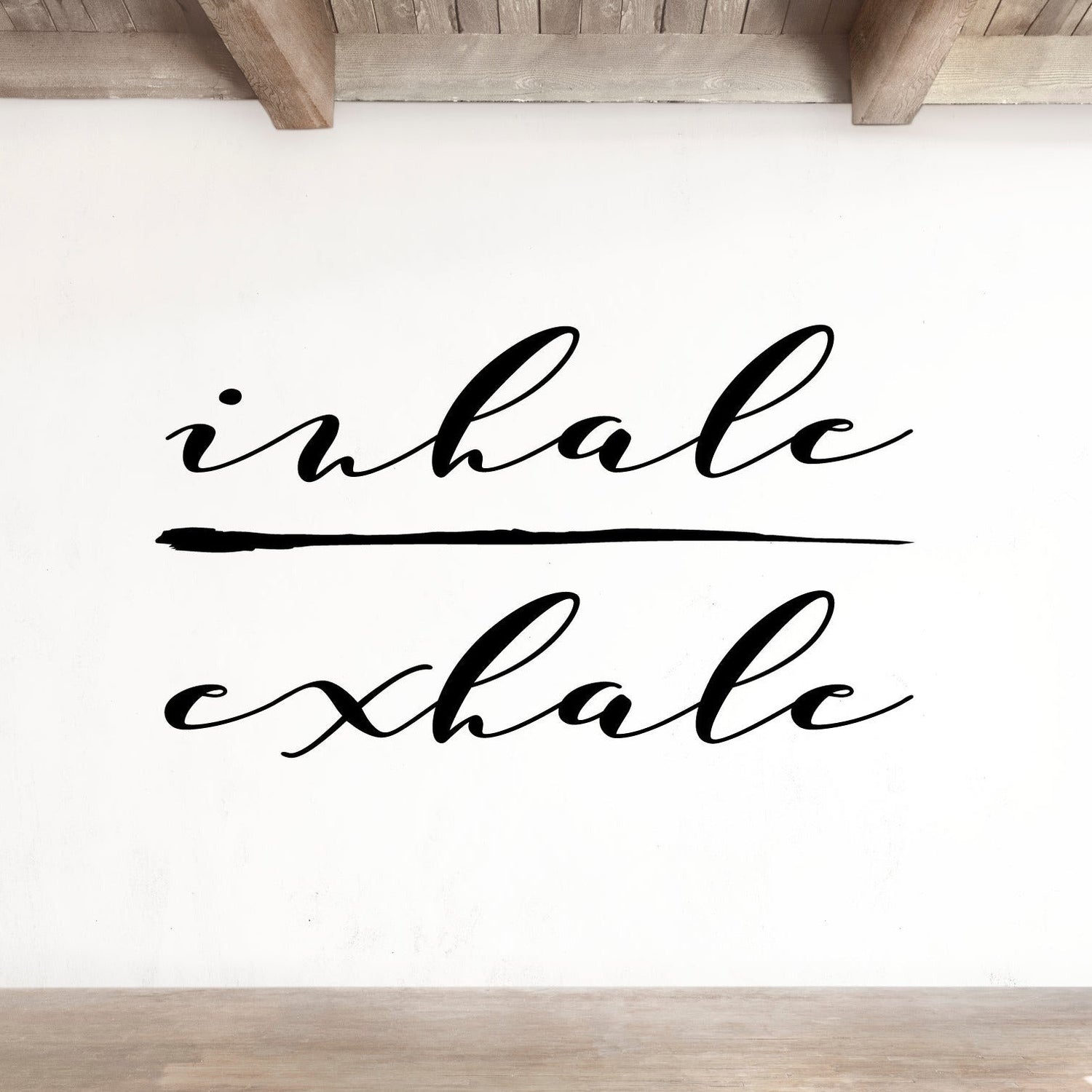 White wall with 'inhalе exhale' text in a minimalist room.