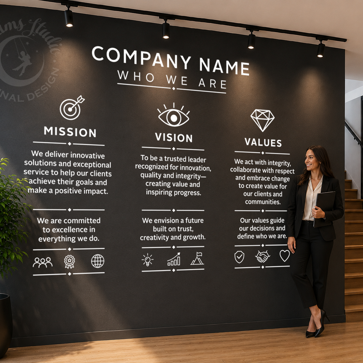 A woman in a black blazer and white blouse stands in front of a large black wall display featuring white text sections for company mission, vision, and values. The setting appears to be an indoor office or showroom with wood flooring, track lighting, and a staircase in the background.