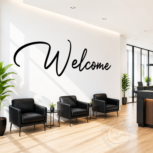 Modern waiting area with black chairs, a welcome sign on the wall, and plants.