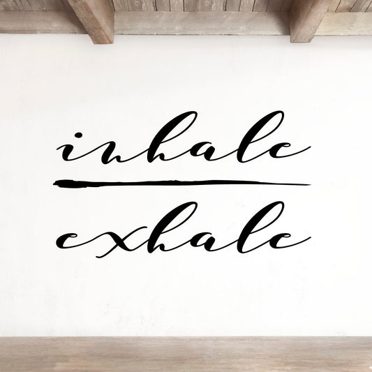 White wall with 'inhalе exhale' text in a minimalist room.