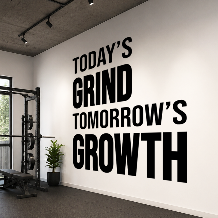 Gym interior with motivational quote 'Today's Grind Tomorrow's Growth' on the wall.