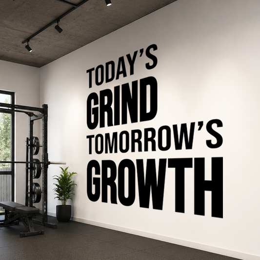 Gym interior with motivational quote 'Today's Grind Tomorrow's Growth' on the wall.