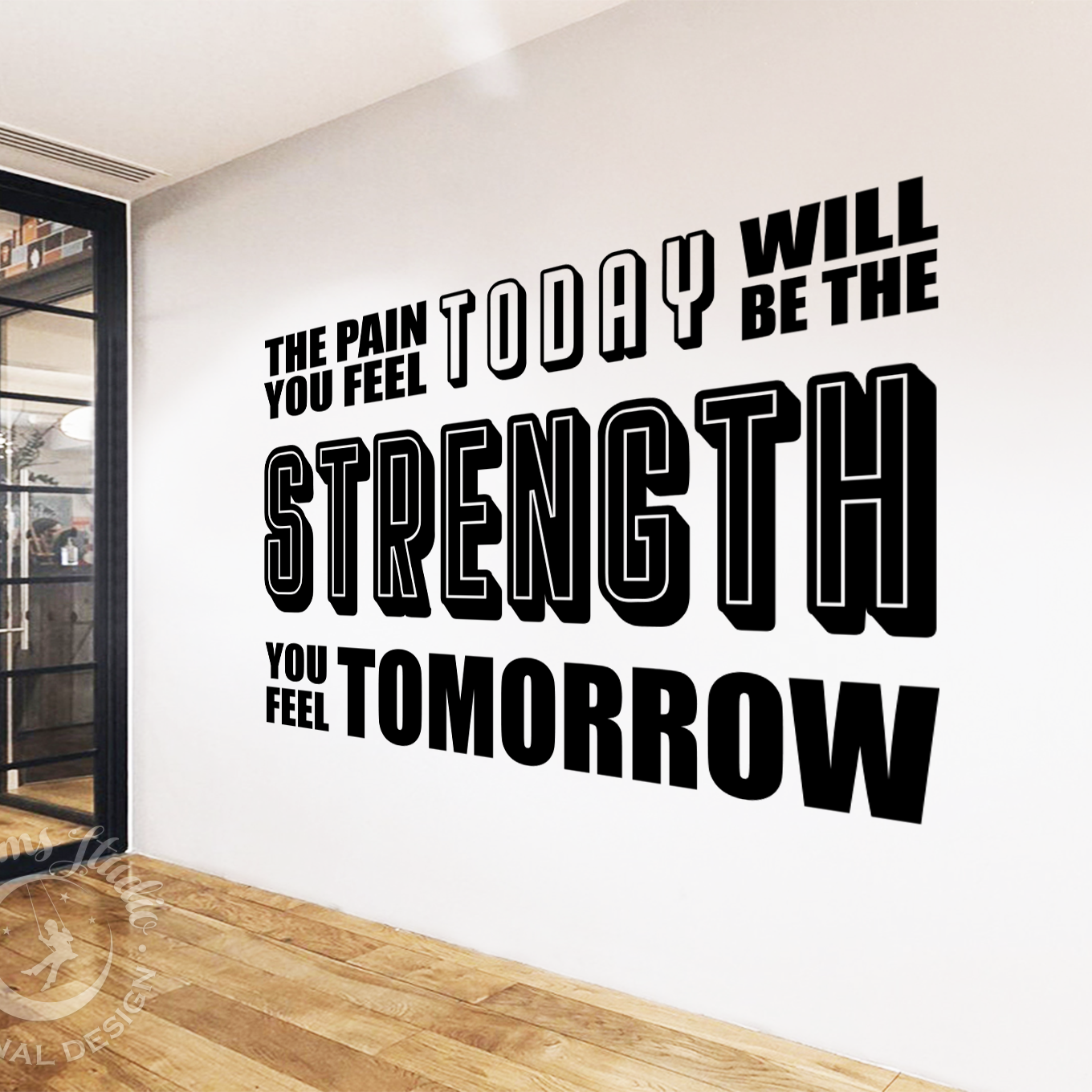 Motivational quote on a wall in a modern interior setting with glass doors.